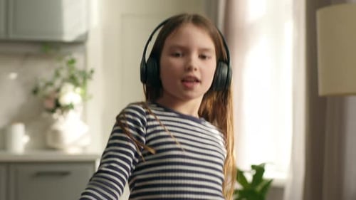 Energetic Girl Listens to Music and Dances at Home