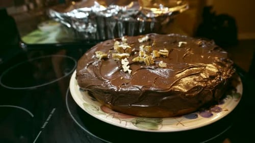 Close-up of Chocolate Cake Being Decorated with Nuts