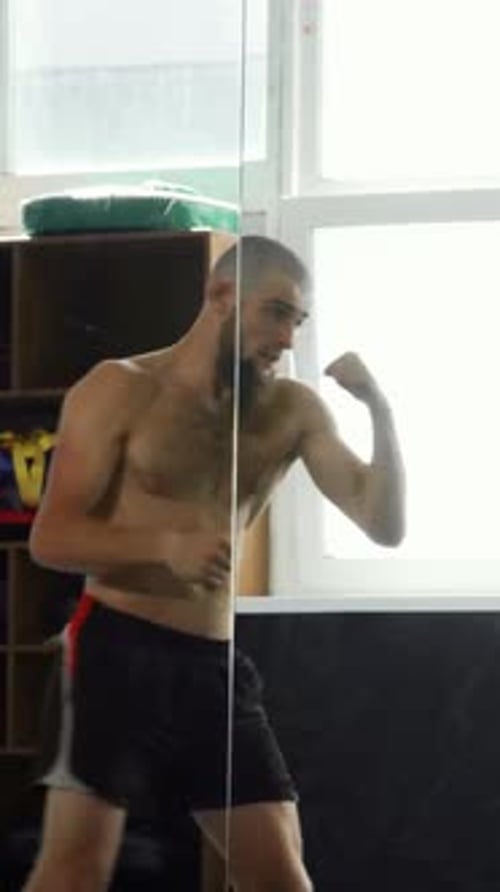 Shirtless Man Boxing, Practicing Punches in Home Gym