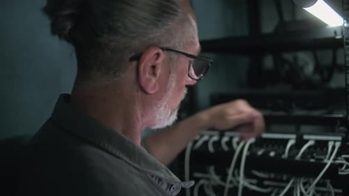 Close Up of System Administrator Inserting Cable Into Server Rack Sets Up Network Equipment