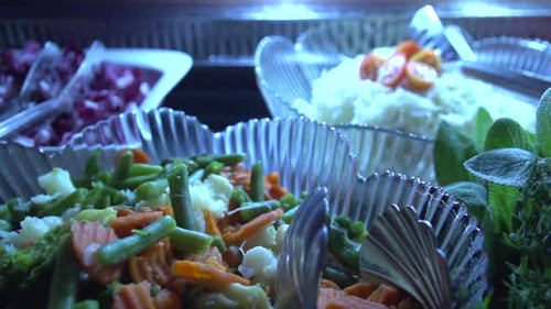 Slow dolly right to left shot of freshly prepared salad for a buffet in a restaurant