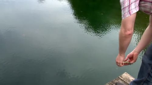 Man Releasing Fish Back Into a Lake