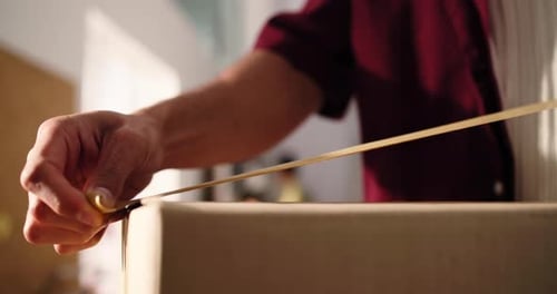 Man Applies Tape to Cardboard Box