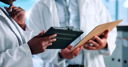 Medical Professionals Reviewing Data on Tablet in Lab