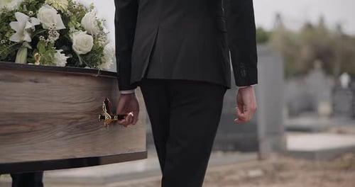 Man Carrying Casket Through Graveyard