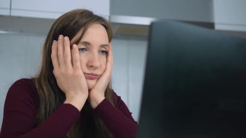 Woman Working Hard Overnight Tired Sitting Holding Head in Hands at Home Office Desk Workplace Think