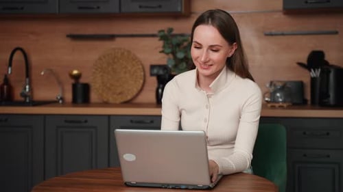 Woman Uses Laptop in Stylish Kitchen