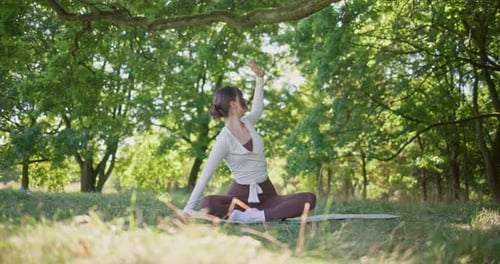 Young Beautiful Athletic Woman in Sportswear Doing Stretching and Warming Up in the Park Near a Tree