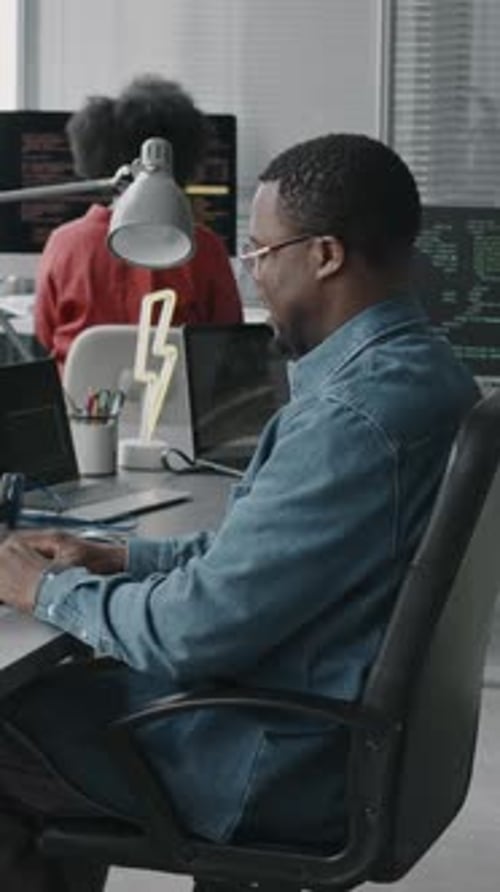 Vertical of Black Male Software Engineer Coding on Computer in Office