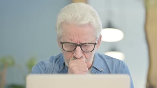 Close Up of Old Man Coughing and Working on Laptop