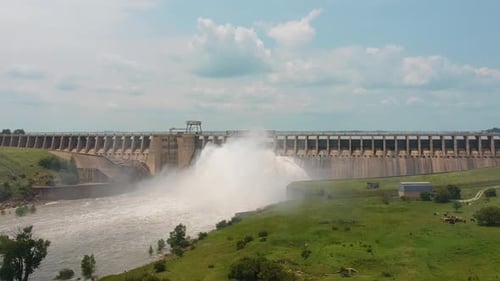 River reservoir releasing water through sluice gates, engineering. Drone push forward shot