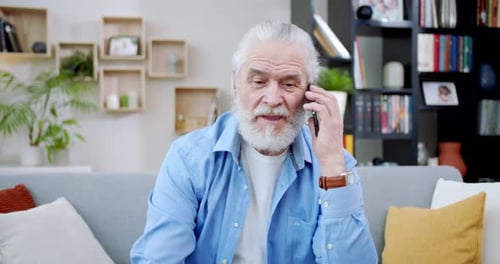 Senior Man Talking on Phone Sitting on Couch