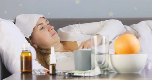 Sick Woman Lying in Bed Checking Temperature