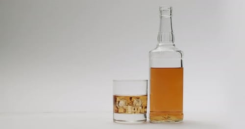 Whiskey in Bottle and Glass with Ice Cubes