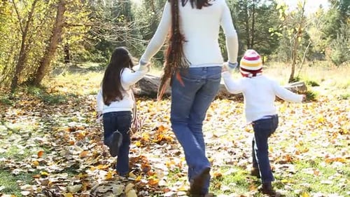Famille heureuse réunie dans un jardin d'automne avec des couleurs et des feuilles d'automne éclatantes