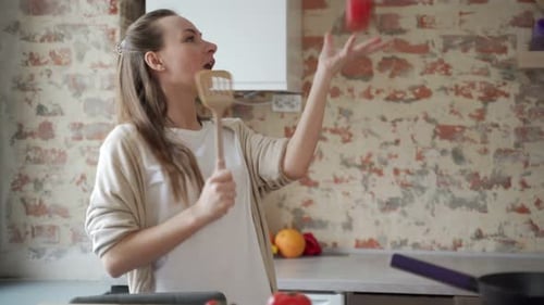 Young Woman Dancing While Cooking in Kitchen
