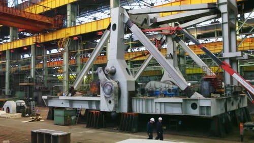Engineers Inspecting Heavy Machinery in Factory