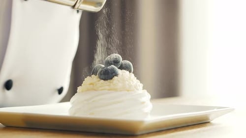 Chef Garnishing Dessert with Powdered Sugar
