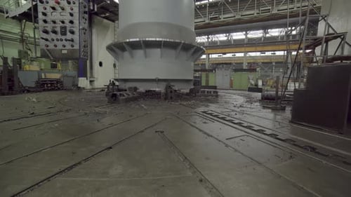 Worker At Giant Machine in Dimly Lit Factory