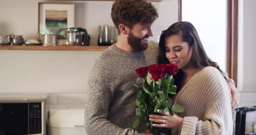 Man Gives Woman Roses in Kitchen