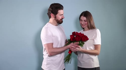 Man Surprising a Woman with a Bouquet of Red Roses