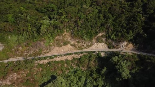 Aerial View of Motobiker Driving on a Road in the Mountains on Summer Day