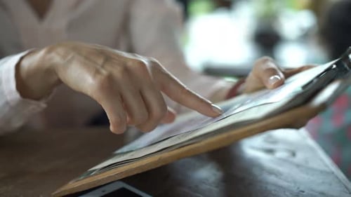 Woman Reading Menu in Cafe
