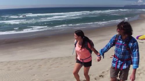 Couple hiking on sand dunes enjoying summer vacation at beach