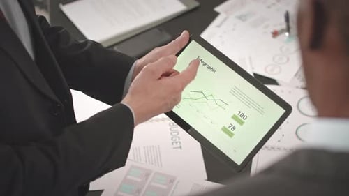 Businessmen Analyze Financial Planning on Tablet