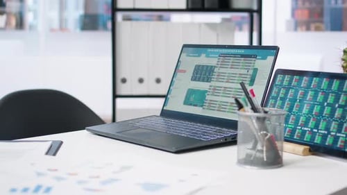 Stock Market Values Going Up and Down on Laptop in Empty Office