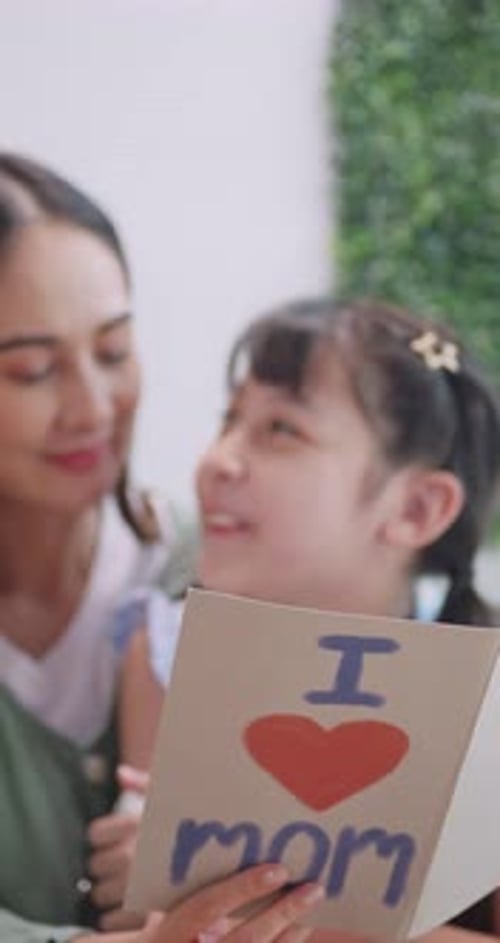 Loving Daughter Presents Mother's Day Card to Mom