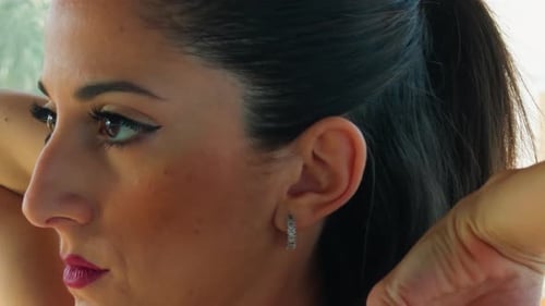 Woman with Dramatic Makeup Puts Hair Up