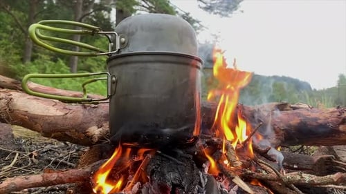 Cooking pot on flaming campfire, Highlands, Scotland
