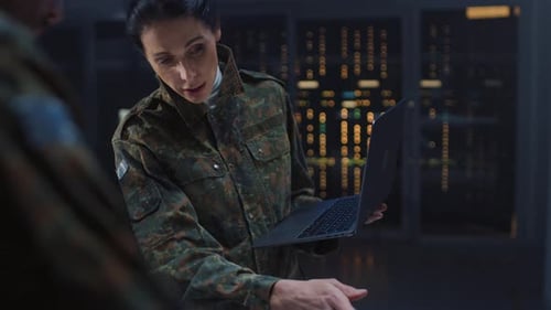 Woman and man discuss work using laptop