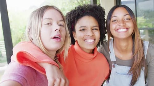 Three Smiling Young Women Posing Together Indoors