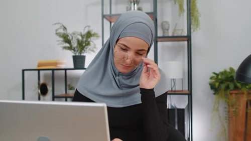 Muslim Business Woman in Hijab Looking at Camera After Finishing Laptop Computer Work at Home Office