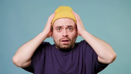 Surprised Man with Hands on Head in Studio