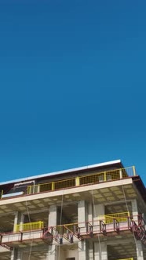 Vertical Video of a Newly Constructed Building Frame Surrounded By Construction Equipment and