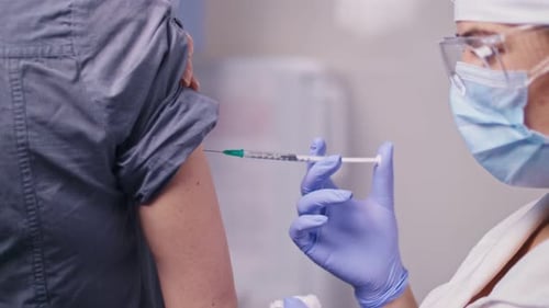 COVID19 Vaccine A Medical Nurse Giving a Vaccine Injection to a Patient in a Clinic The Doctor Uses
