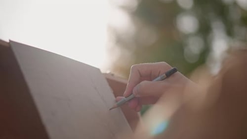 Im Freien im Park skizzieren, draußen in einer ruhigen Parkumgebung Kunstwerke schaffen Ein Künstler bei der Arbeit