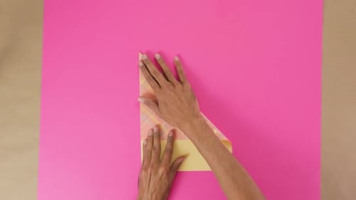 Hands Folding Paper Sheets for Origami Project