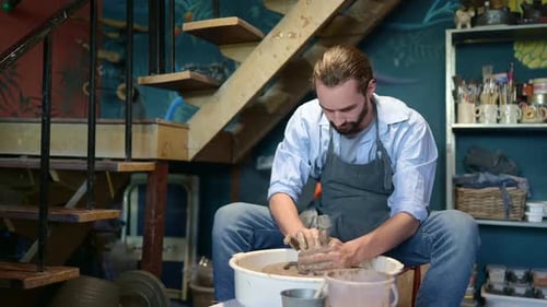 Bearded Man Shapes Clay on Pottery Wheel