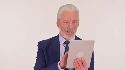 Senior Man Celebrates While Using Tablet