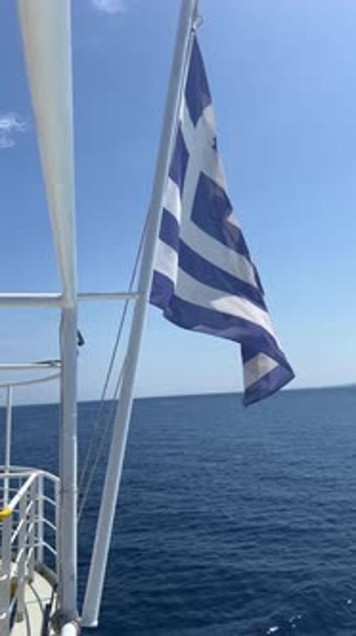 Greek National Flag Waving and the Water Wake Done By a Speeding Boat