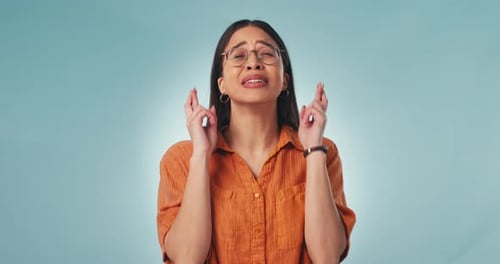Hope, face and woman with fingers crossed in studio for feedback, results