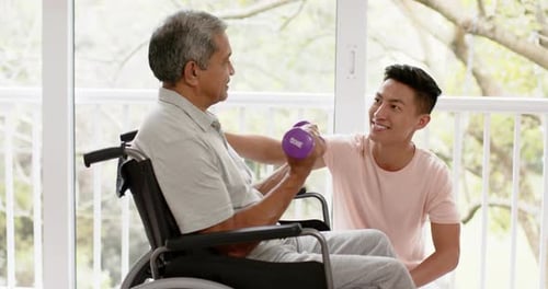 Senior Man Lifts Weights with Adult Assistance