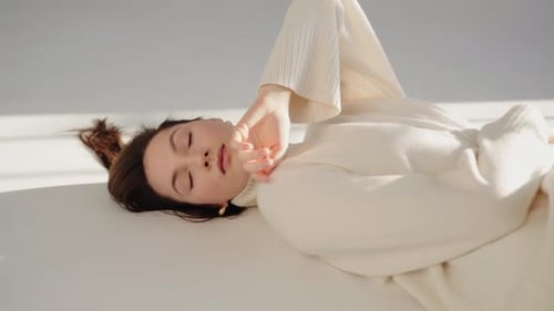 Woman Lying Down in Cream Sweater