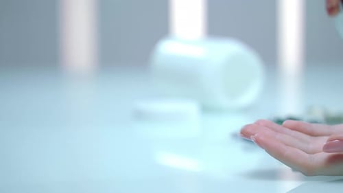Woman pours colorful pills into her hand