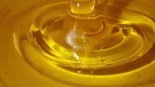 Macro Shoot of Thick Liquid Drop of Oil or Honey Falling Over Black Background