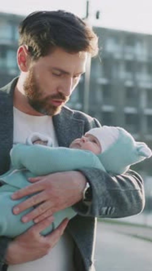 Happy Young Father Holds a Small Cute New Born Daughter at Sunlight Stand in the Park Near Lake